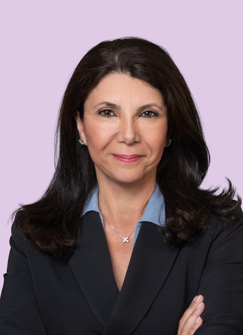 Meg Razi abogada morena con americana negra