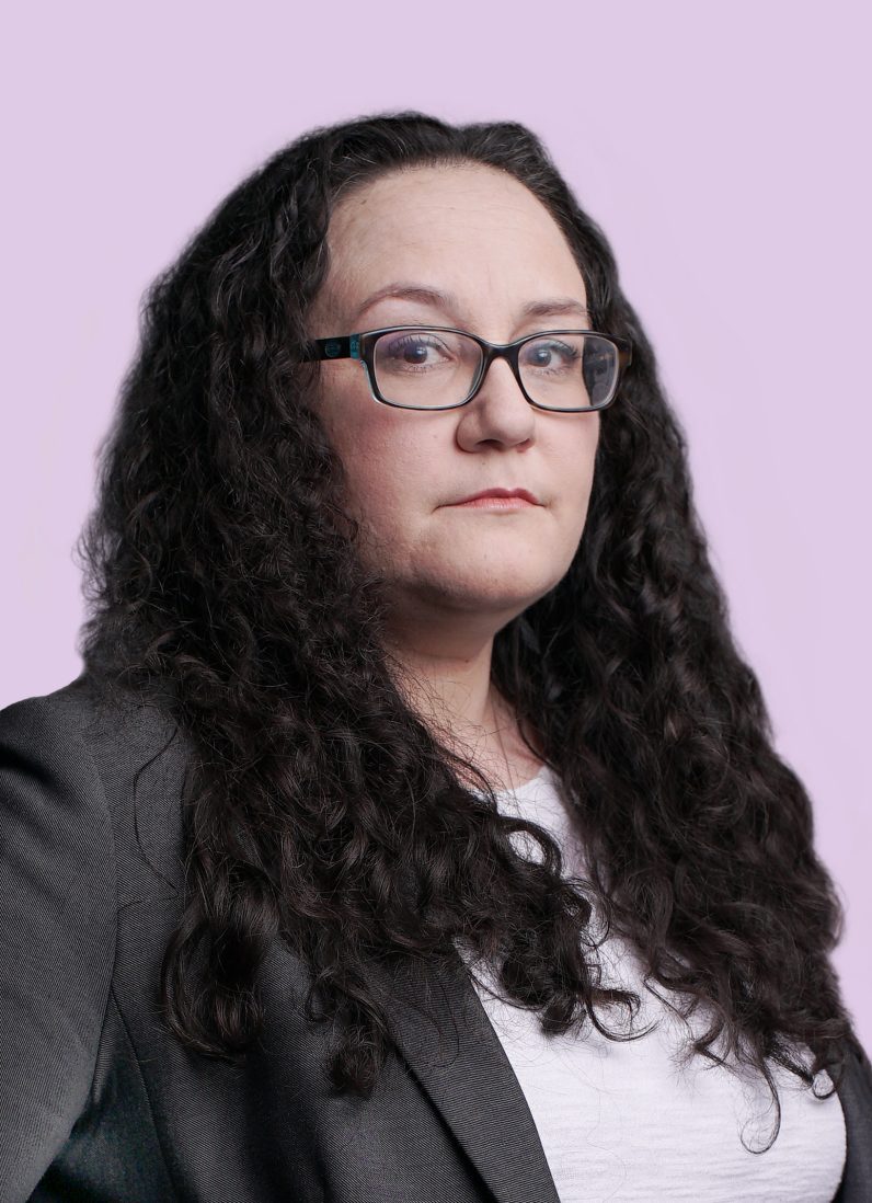 Melissa Leblanc abogada con americana gris y camiseta blanca y gafas